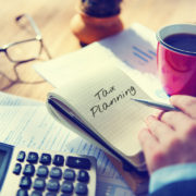 Man with calculator, coffee and stationery to start planning his tax