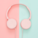 A pair of headphones on a pink and blue background