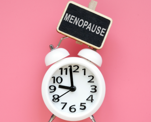 A clock with a sign above it reading menopause