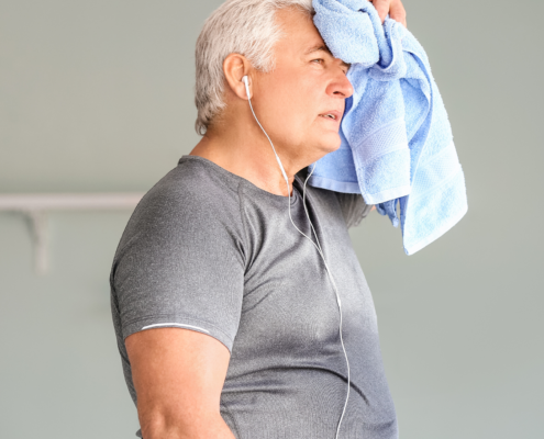 A white older man holding a sweat towel to his head