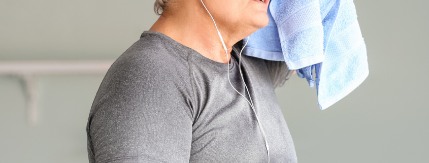 A white older man holding a sweat towel to his head