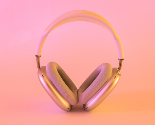 Rose gold headphones on a pink gradient background