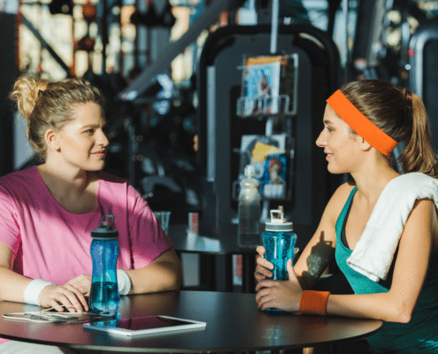 Exercise instructor talking to member at gym